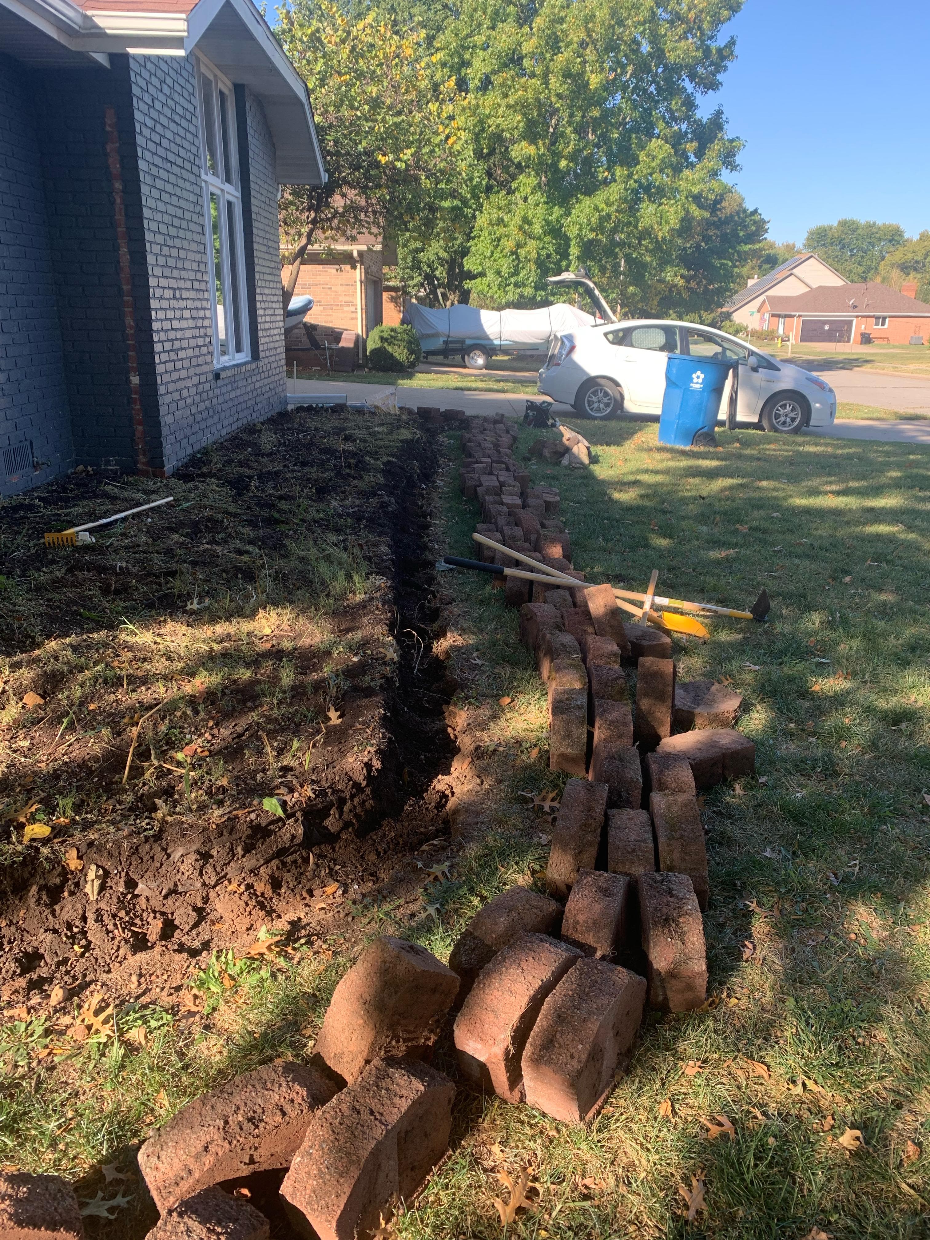 Landscape edging installation with brick border in progress