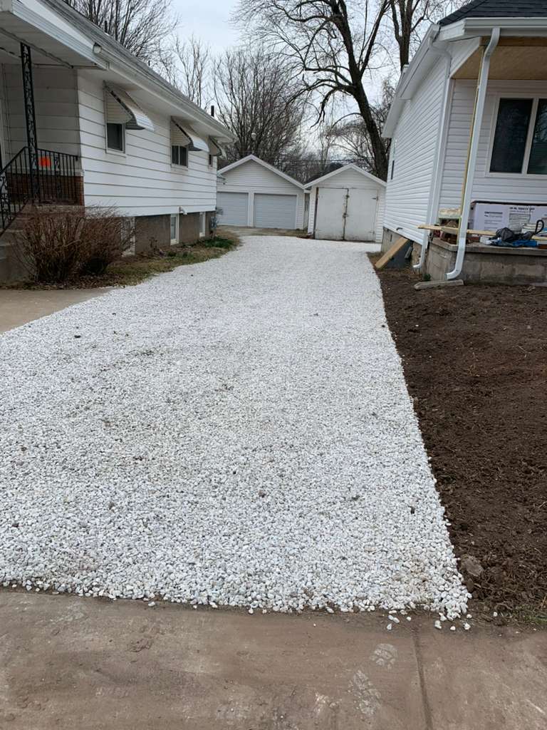 White gravel driveway installation between houses